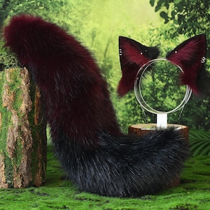 May include: A burgundy and black faux fur tail and matching cat ear headband set. The tail is thick and fluffy, changing from burgundy to black. The headband features burgundy ears with silver accents, ideal for cosplay or costume.