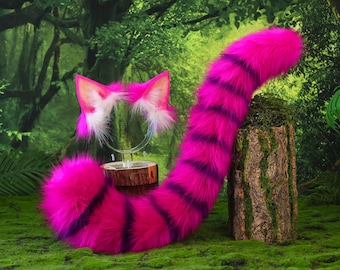 May include: A set consisting of a pair of faux fur cat ears on a headband and a long, matching faux fur tail. Both items feature a vibrant hot pink colour with dark purple horizontal stripes and white inner ear accents, crafted from plush material.
