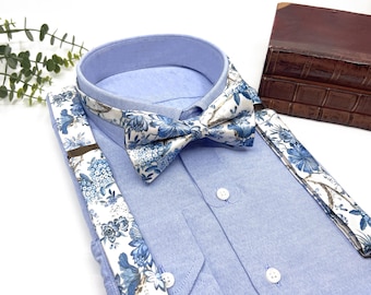 May include: A white dress shirt with a blue floral bow tie and matching suspenders. The bow tie and suspenders have a white background with blue floral designs.