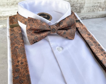 Puede incluir: Una camisa blanca con una pajarita y tirantes con estampado floral marrón. La pajarita y los tirantes tienen un diseño a juego. La camisa está abotonada y lista para usar.