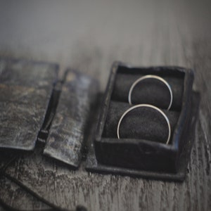 May include: Two silver rings in a black leather ring box with a black velvet interior.