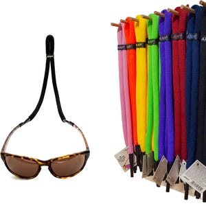 Puede incluir: Exhibición de correas de gafas de sol de colores, incluyendo rosa, amarillo, verde, morado, rojo, azul y negro. También se muestra un par de gafas de sol carey con una correa negra. Las correas están etiquetadas con la marca "AJUY".