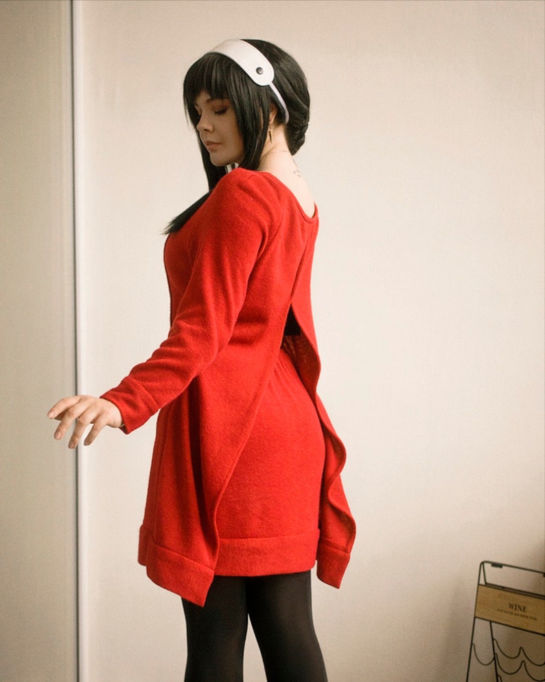 May include: A woman wearing a red dress with a back slit and a white headband. The dress has a loose fit and is made of a soft, comfortable fabric.