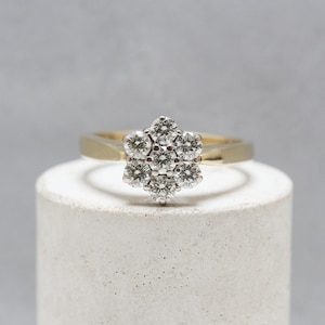 18ct Gold, Diamond Daisy Cluster Ring. seven round brilliant cut diamonds, weighing an estimated total of 0.75ct Size (UK) N 1/2