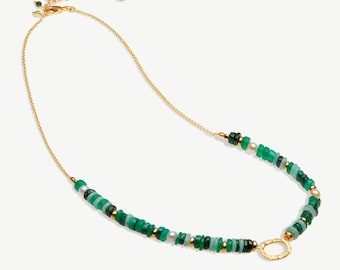 May include: A gold chain necklace with a green and white beaded strand. The beads are various sizes and shapes, and there is a small gold circle charm.