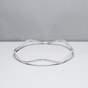 May include: A silver wavy bangle bracelet.