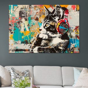 Puede incluir: Una pintura abstracta colorida de un gato con auriculares rojos y azules. El gato está sentado sobre un fondo de grafitis coloridos.