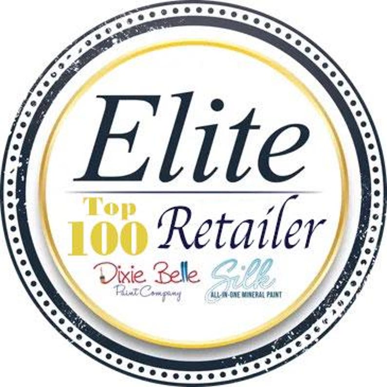K&ouml;nnte beinhalten: Ein kreisf&ouml;rmiges Abzeichen mit einem dunkelblauen Rand und wei&szlig;en Punkten. Die Mitte ist wei&szlig; mit goldener Umrandung und zeigt den Text Elite Top 100 Retailer in Dunkelblau und Gold. Darunter sind die Logos von Dixie Belle Paint Company und Silk.