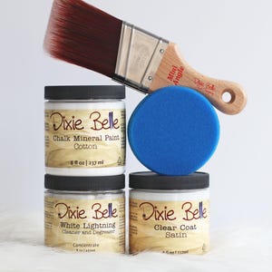 May include: A set of three 8 fl oz jars of Dixie Belle products including Cotton Chalk Mineral Paint, White Lightning Cleaner and Degreaser, and Satin Clear Coat. A blue round foam applicator and a wooden Mini Angle paintbrush are included.