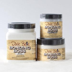 May include: Three glass jars of Dixie Belle Bonding Boss Problem Solver in white, gray, and clear. The jars are labeled with the product name, size, and color.  The jars are on a white surface.