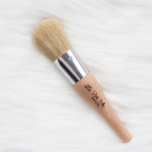 May include: A wooden-handled brush with a silver ferrule and natural bristles. The brush is labeled "Dixie Belle The Belle Made in USA".
