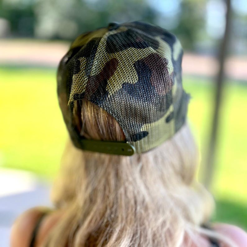 Pode incluir: Bon&eacute; de beisebol com estampa camuflada com parte traseira em malha e aba curva. O bon&eacute; apresenta tons de verde, marrom e preto. A al&ccedil;a ajust&aacute;vel &eacute; verde-oliva.
