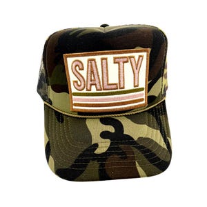 May include: A camouflage trucker hat with a white patch that says "SALTY" in pink and green letters. The patch has brown stripes.