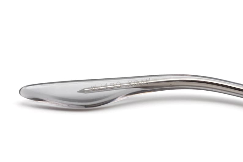 May include: Close-up of a silver-colored metal temple tip with the text "W1289 104V" engraved on it.