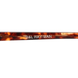 May include: Close-up of the arm of a pair of tortoiseshell sunglasses with the text "B&L RAY-BAN" printed on the arm.
