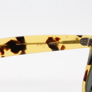 Puede incluir: Primer plano de gafas de sol con estampado de carey. La patilla de las gafas de sol es de color amarillo transl&uacute;cido con manchas marrones oscuras. La palabra "WATTAKER" est&aacute; impresa en la patilla.