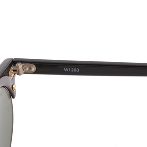 May include: Black sunglasses with a silver hinge and the text "W1263" on the arm.