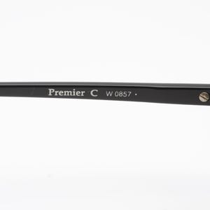 May include: Black plastic frame of a pair of glasses with the text "Premier C W 0857." printed on the side.