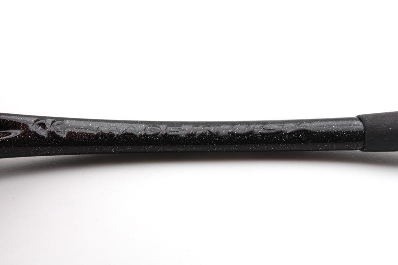Puede incluir: Primer plano de un objeto negro y moteado con el texto "MADE IN USA" visible. El objeto tiene una forma curva y una superficie texturizada. El extremo del objeto es de color negro s&oacute;lido.