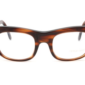 May include: Tortoise shell eyeglasses with a clear lens and the text "Giorgio Armani" printed on the right lens.