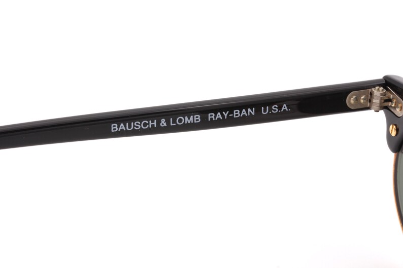 May include: Black Ray-Ban sunglasses with a metal hinge and the text "BAUSCH & LOMB RAY-BAN U.S.A." printed on the arm.