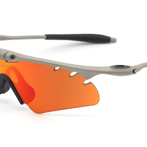 May include: A pair of gray wraparound sunglasses with orange lenses. The sunglasses have a black rubber nose piece and ear pieces.