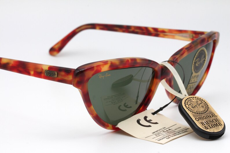 May include: Tortoiseshell Ray-Ban sunglasses with green lenses. The sunglasses have a tag that reads "Original Bausch & Lomb".