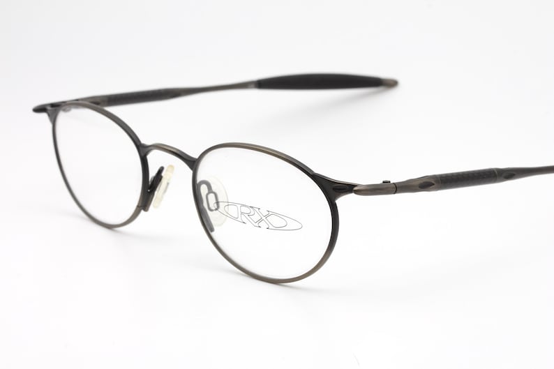 May include: A pair of black metal eyeglasses with round lenses. The brand name "ORXO" is visible on the lenses.