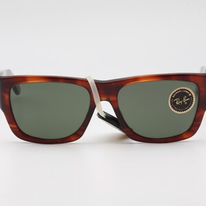 Puede incluir: Gafas de sol carey marr&oacute;n con lentes verdes. Las gafas de sol tienen una montura rectangular y una peque&ntilde;a pegatina en la lente derecha. Las gafas de sol son nuevas y tienen una etiqueta blanca.
