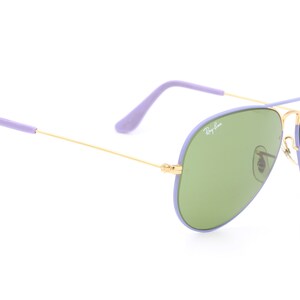 Op de afbeelding: Paarse en gouden aviator zonnebril met groene glazen. De zonnebril heeft een Ray-Ban logo op de rechter lens.