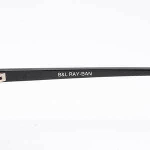 May include: Black Ray-Ban aviator sunglasses with green lenses. The sunglasses have a metal frame and the text "B&L RAY-BAN" is printed on the frame.