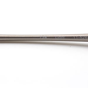 May include: A close-up of a metallic gray object with the text "134 Liont 11-526" printed on it. The object has a smooth, cylindrical shape and is set against a white background.