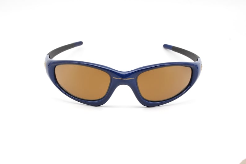 May include: A pair of blue sunglasses with brown lenses. The sunglasses have a sporty, wraparound design.