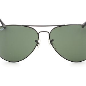 May include: Black aviator sunglasses with green lenses and Ray-Ban branding on the left temple.