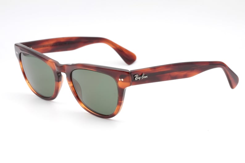 May include: Brown tortoiseshell Ray-Ban sunglasses with green lenses. The sunglasses have a classic aviator style frame.