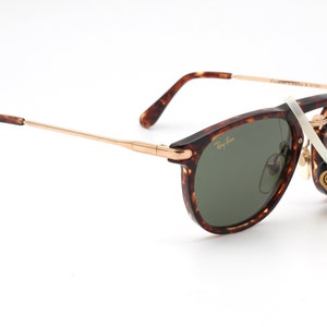 Op de afbeelding: Schildpad Ray-Ban zonnebril met groene glazen en gouden accenten. De zonnebril heeft een label met de tekst "Original Bausch & Lomb".