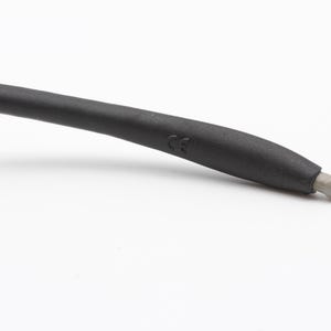 May include: Close-up of a black rubber temple tip with a CE marking. The tip is designed to fit comfortably on the ear.