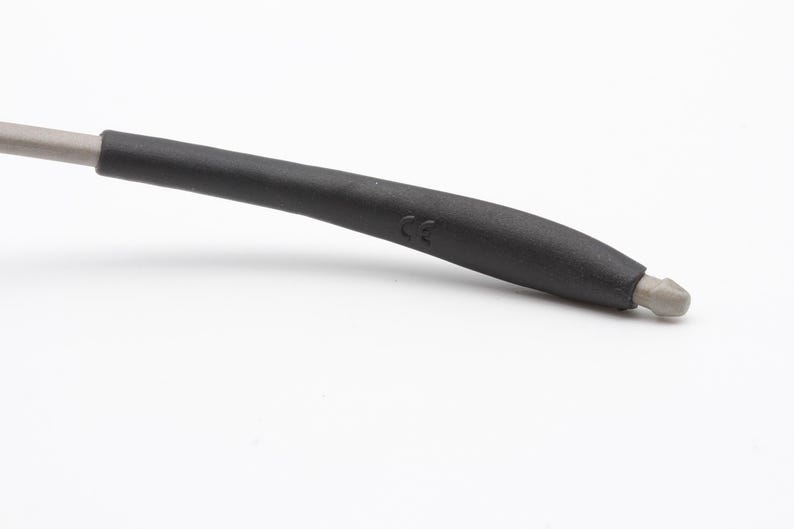 May include: Close-up of a black rubber temple tip with a CE marking. The tip is designed to fit comfortably on the ear.