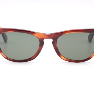 May include: Tortoiseshell sunglasses with green lenses. The sunglasses have a classic, retro style.