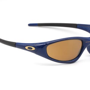 May include: Blue and gold framed sunglasses with brown lenses. The sunglasses have a sporty design.