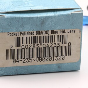 May include: A blue and white box with a barcode and the text "Pocket Polished Blk/(00) Blue Irid. Lens 7 00285 04235 04-235~000001320 05/13/93"