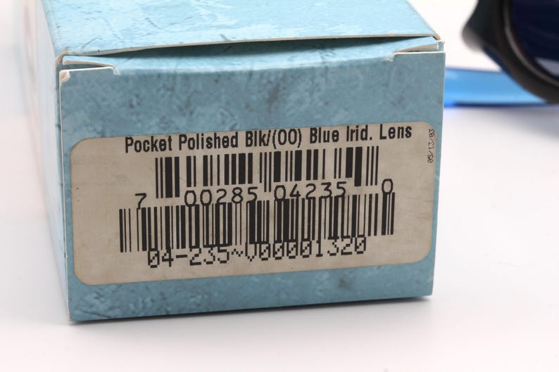 May include: A blue and white box with a barcode and the text "Pocket Polished Blk/(00) Blue Irid. Lens 7 00285 04235 04-235~000001320 05/13/93"