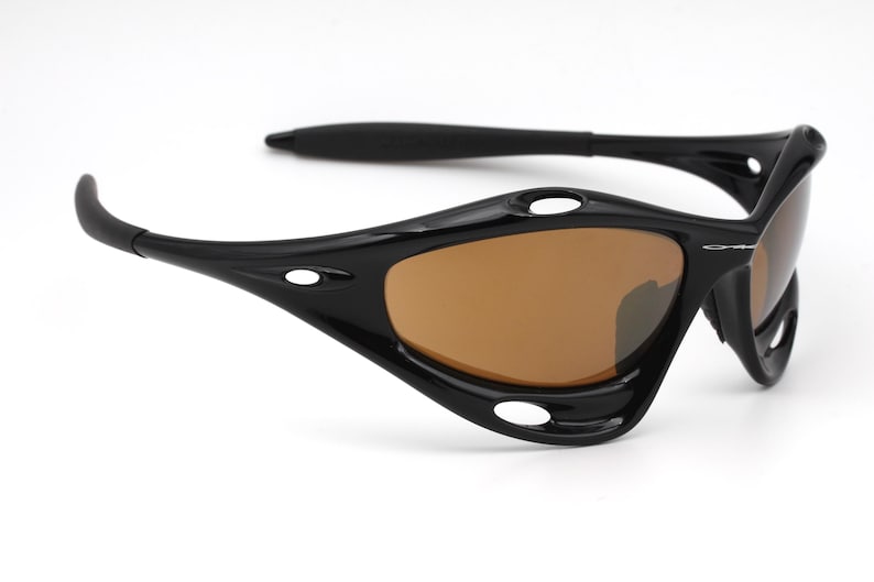 May include: Black wraparound sunglasses with brown lenses. The sunglasses have a sporty design with multiple vents and a curved frame.