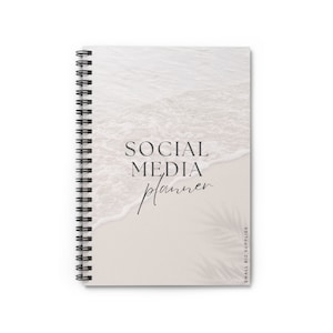 May include: A white and beige social media planner with a beach scene and the text "SOCIAL MEDIA planner" on the cover.