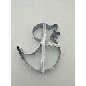 May include: A metal cookie cutter shaped like a duck. The cutter is made of thin metal and has a simple design.