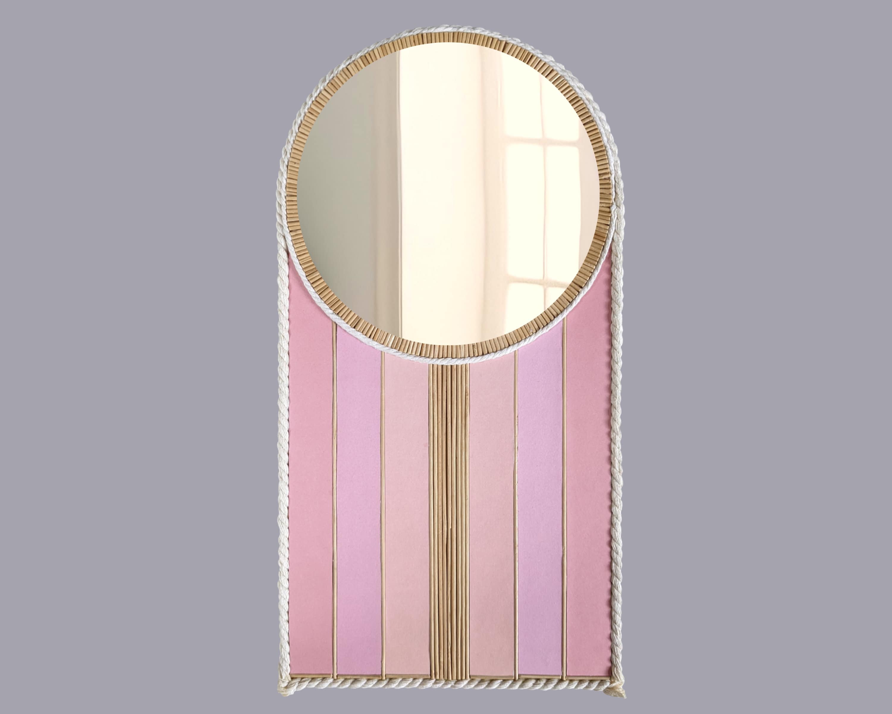 Ein spiegel mit rosa hintergrund und einem weißen rahmen mit rosa