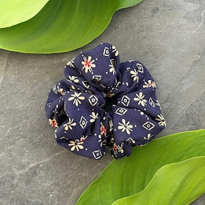 Può includere: Una tazza di ceramica bianca con manico nero e la scritta "But First, Coffee" in grassetto nero. La tazza è posta su uno sfondo sfocato, che suggerisce un'atmosfera accogliente.