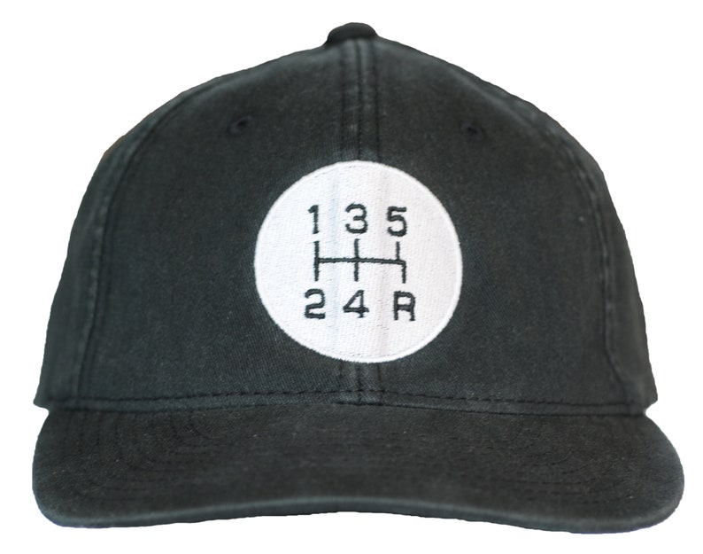 May include: Black baseball cap with a white circle and black embroidered text that reads "1 3 5 2 4 R" resembling a car's gear shift pattern.