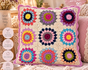 Könnte beinhalten: Ein quadratischer Kissenbezug aus Häkelarbeit mit neun kreisförmigen Granny-Square-Motiven in verschiedenen Farben wie Pink, Gelb, Blau, Lila und Grün auf cremefarbenem Grund mit einem gewellten, helllila Rand.
