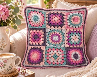 Könnte beinhalten: Ein quadratischer Kissenbezug aus Häkelarbeit mit einem Raster aus neun Granny Squares in den Farben Rosa, Lila, Türkis und Weiß. Das Design besteht aus abwechselnden blumenartigen kreisförmigen Zentren und klassischen Quadratmustern.